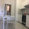 Cucina moderna con tavolo bianco, sedie e mobili bianchi.