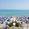 Spiaggia con ombrelloni blu e mare calmo.