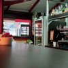 Bancone di un bar con macchina da caffè e bottiglie sugli scaffali.