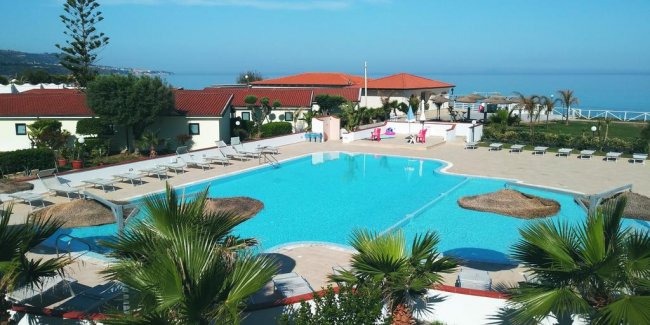 Piscina con lettini, vista mare.