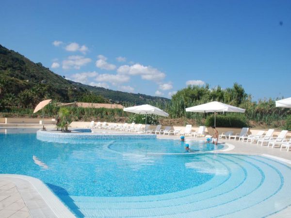 Piscina all'aperto con sedie a sdraio.